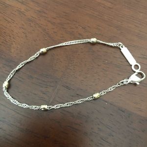 Delicate twisted silver bracelet with gold accents